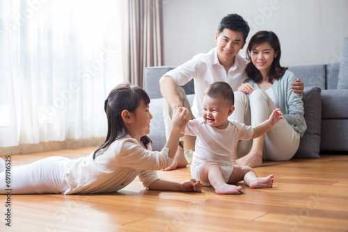Happy young family lying on wooden floor photo