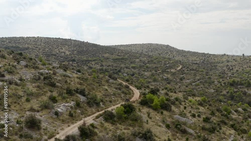 Buggy Driving In Scenic Mountains Near Pustinja Blaca On Brac Island, Dalmatia, Croatia - Aerial Shot photo