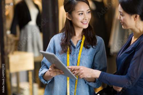 Fashion designer and customer using digital tablet