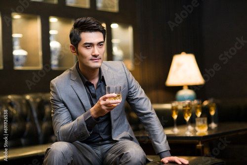 Young man drinking alcohol in luxury club photo