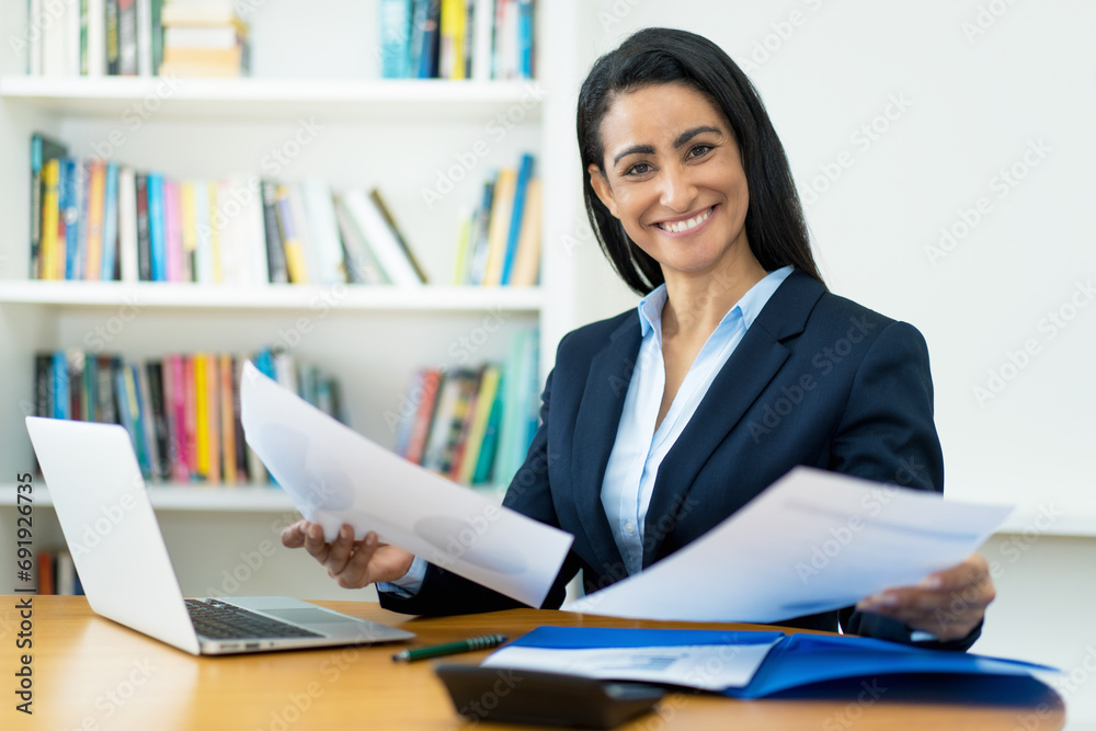 Motivated hispanic mature businesswoman working with documents at desk Motivated hispanic mature businesswoman working with documents at desk