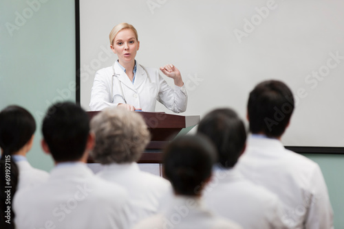 Female doctor giving speech in boardroom photo