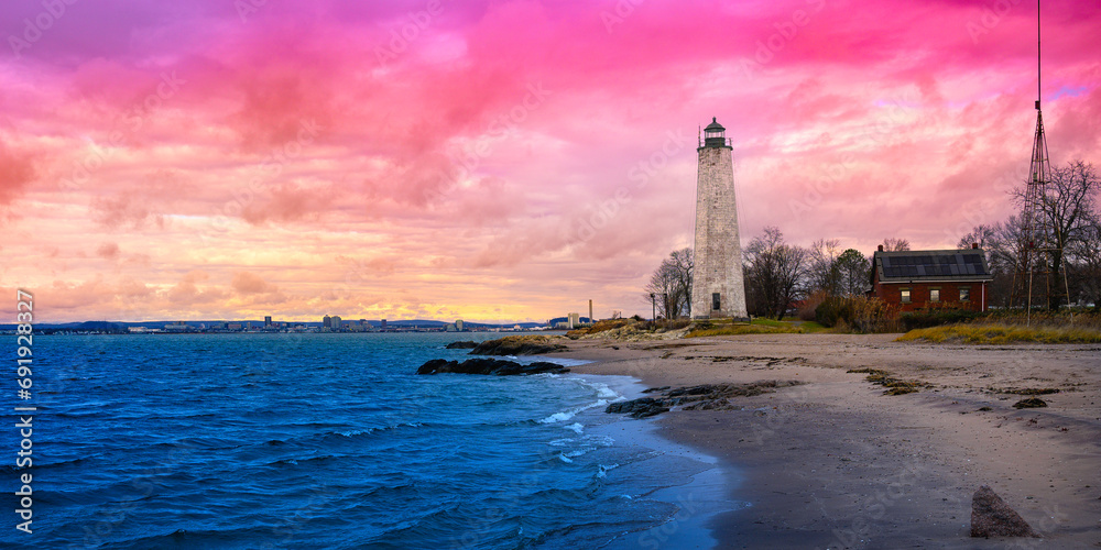 New Haven Landmark Lighthouse at the beachfront of Morgan Point Park, built in 1847 in Connecticut. Winter coastal landscape in New England at dramatic cloudy sunset in America.