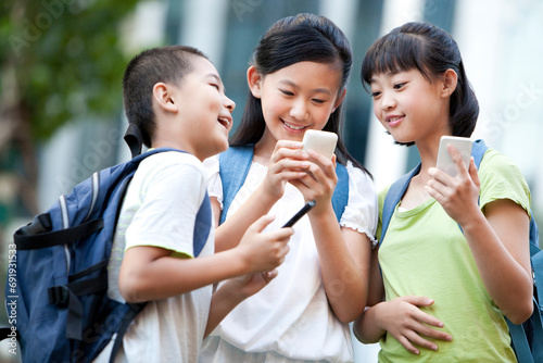 Schoolchildren using smart phones photo