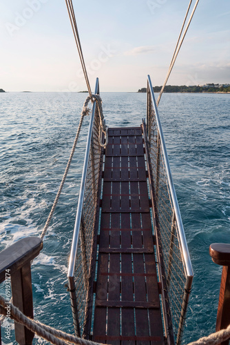 Tableau sur toile a brown wooden gangway with railing while sailing on the ocean