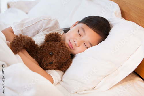 Little girl sleeping soundly with teddy bear photo