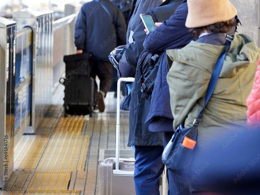 冬の新幹線のホームの電車待ちの人々の姿