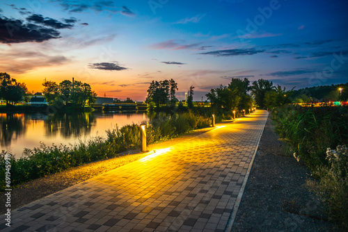 Oświetlona alejka nad jeziorem photo