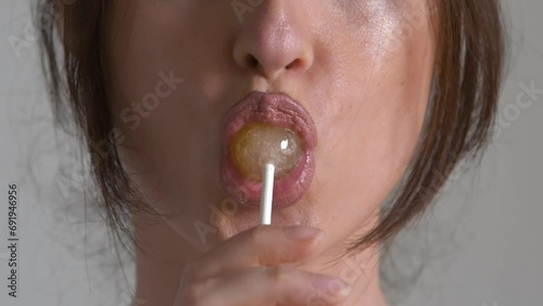 Woman licking sweet sugar candy closeup photo