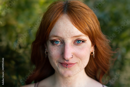 Portrait of redhead girl with blue eyes on nature photo