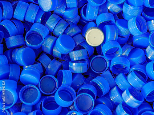 Grey plastic bottle caps on top to depict the concept of standing out from the crowd, dare to be different, odd man out, success or a leadership concept.