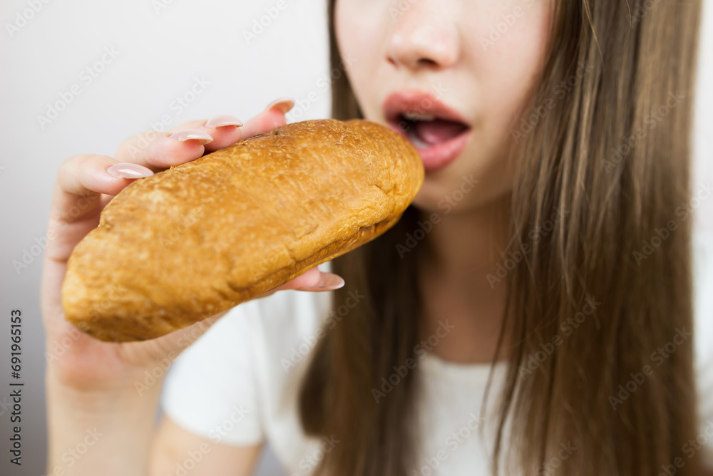 Close-up photo of a woman eating a croissant