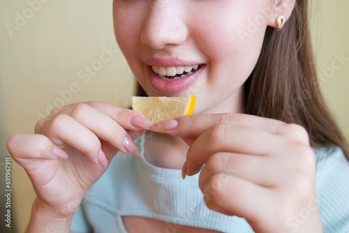 beautiful woman eating lemon, close-up.