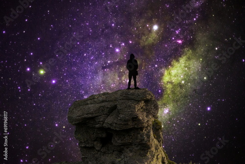 silhouette of a person in on the top of the mountain with galaxy space photo
