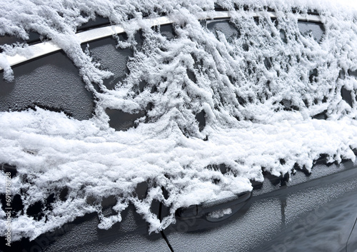 Frozen car. Car covered with snow and frost. Part of the car under snow after a heavy snowfall. The body of the car is covered with snow after blizzard © Aleksei