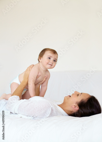 Happy, baby and mother playing on bed, love and affection or bonding with toddler, smile and connection. Mom, kid and child development at home, care and support or security, motherhood and bedroom