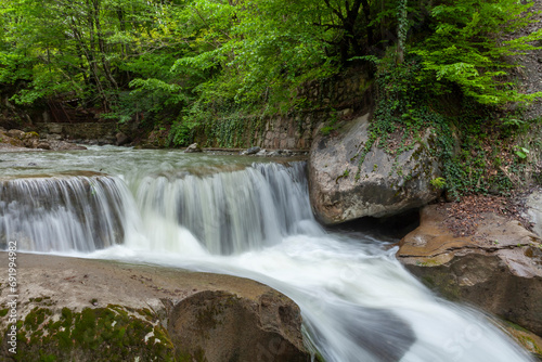 The waterfall flowing through mossy rocks and the water shot like a veil with a long exposure technique