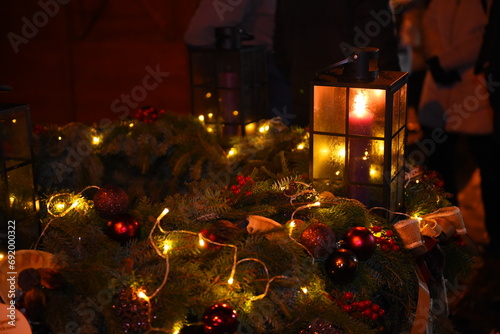 Closeup of fir leaves adorned for Christmas and a lit lamp