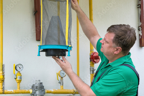 A man hangs reusable trap for flies and muskies near his house. photo