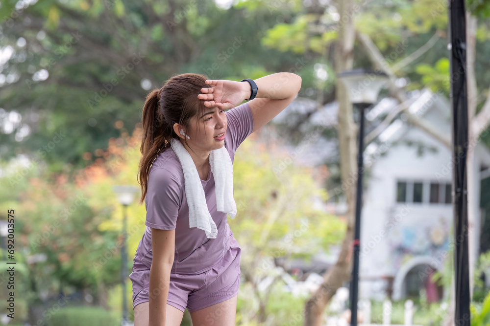 Young Asian woman who is tired from exercising Stretch for health care in the park. Young Asian woman who is tired from exercising Stretch for health care in the park.