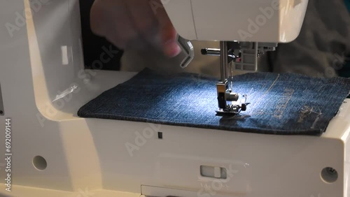 Man and child using a sewing machine with a blue garment, for repair work, customization, creation, upcycling photo