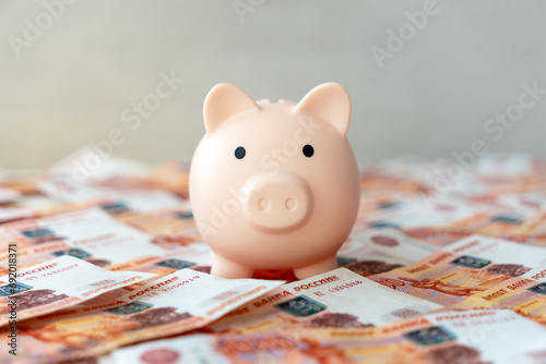 Pink piggy bank with Russian money banknotes currency rouble in nominal value of five thousand. concept of saving accumulating money. photo