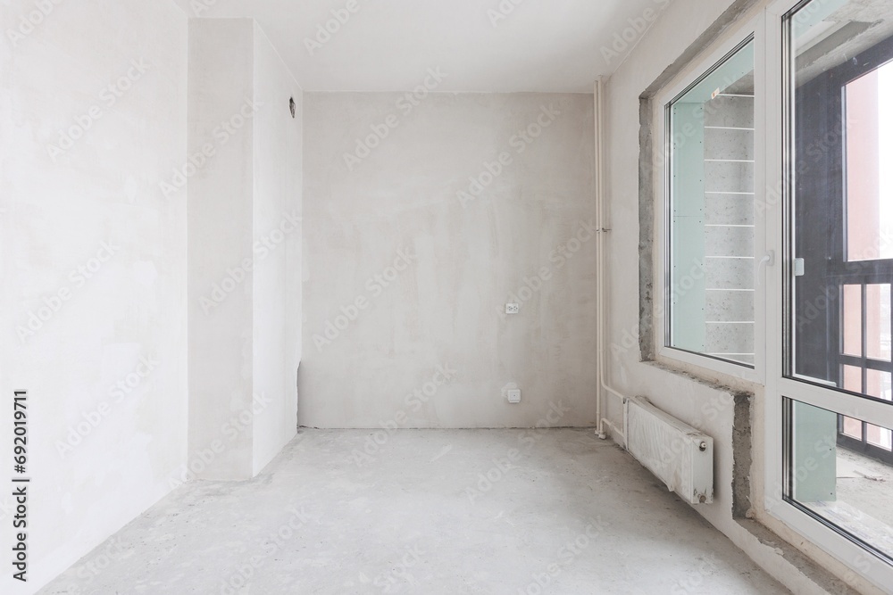 Obraz premium interior of the apartment without decoration in gray colors. rough finish