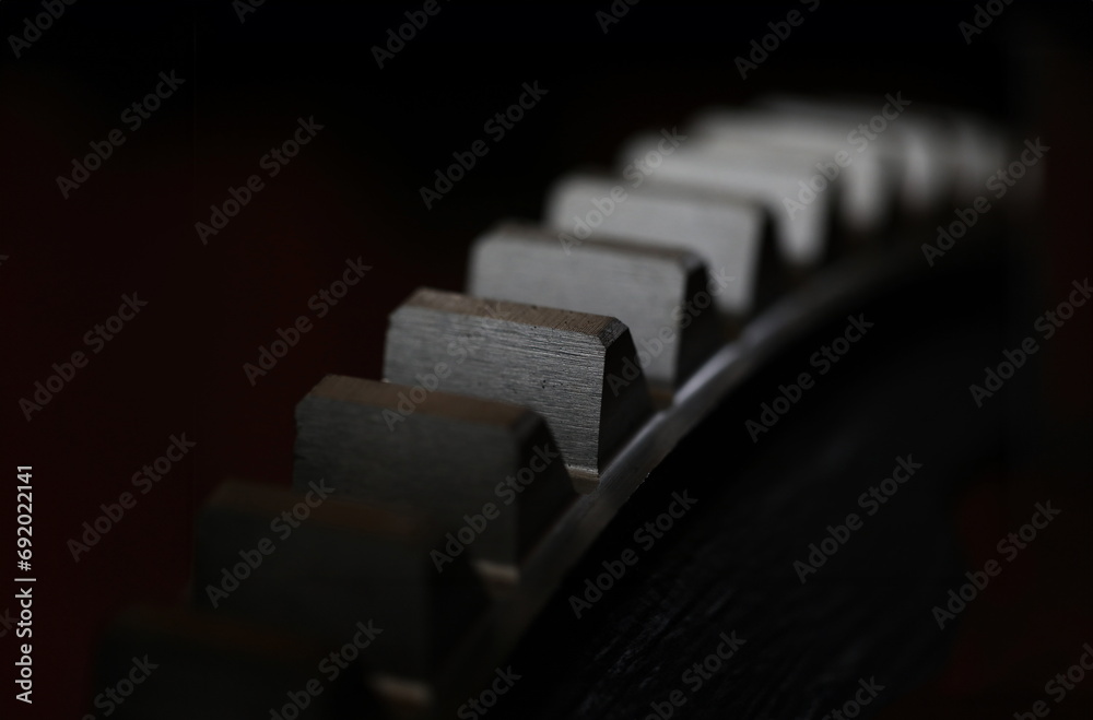 Closeup of metal cogwheel on dark background as part of full machine and steampunk concept Closeup of metal cogwheel on dark background as part of full machine and steampunk concept