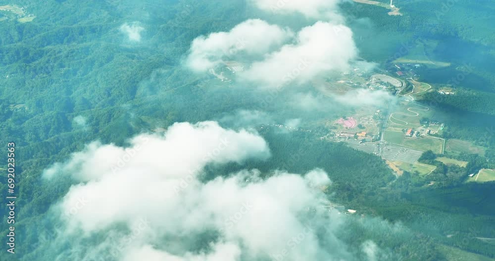 Aerial view of unidentified green moutains and town in Japan ,taken from plane window