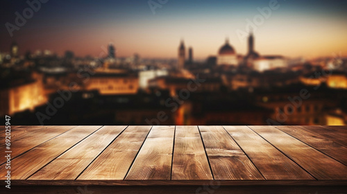 Empty wooden table with panoramic view at historic European city with cathedral at night with european arquitecture aglow with night lights. photo