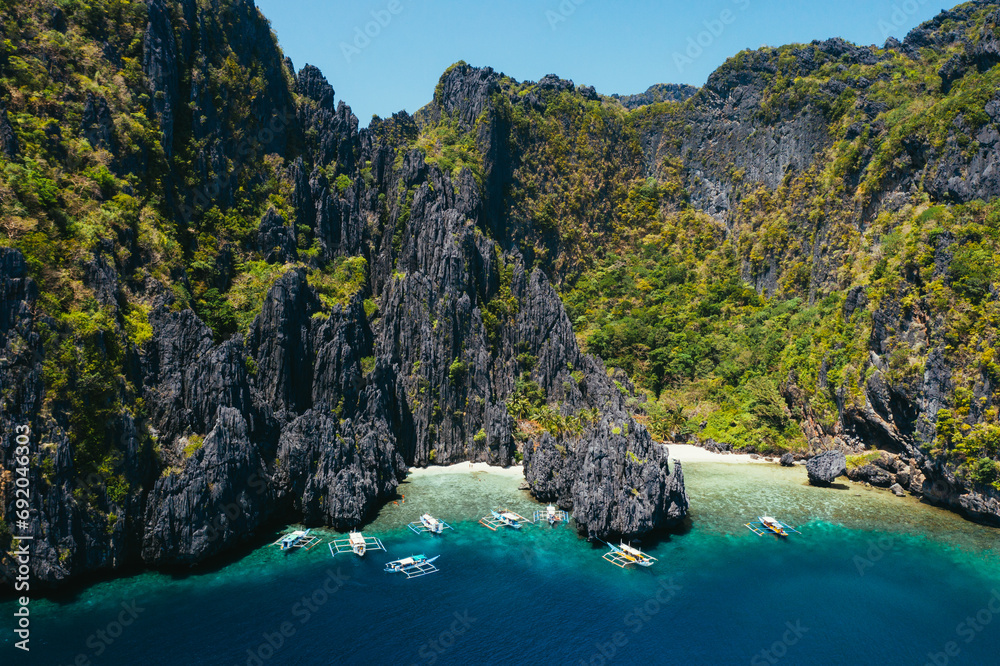 Small lagoon in El nido. People walking on the white sand, with tropical jungle in the background. Concept about traveling and nature Small lagoon in El nido. People walking on the white sand, with tropical jungle in the background. Concept about traveling and nature