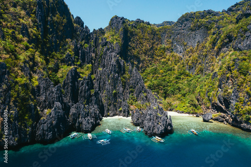 Small lagoon in El nido. People walking on the white sand, with tropical jungle in the background. Concept about traveling and nature