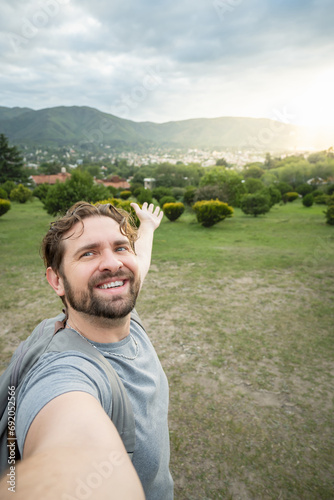 Young man takes a selfie in a beautiful nature park.
