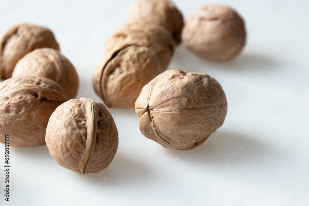 Walnuts on a white background. Close-up, selective focus. Walnuts on a white background. Close-up, selective focus.