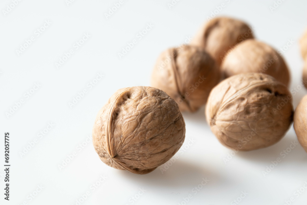 Walnuts on a white background. Close-up, selective focus. Walnuts on a white background. Close-up, selective focus.