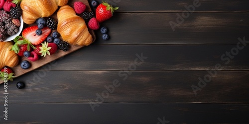 croissant and fruits on wooden background with space for text photo