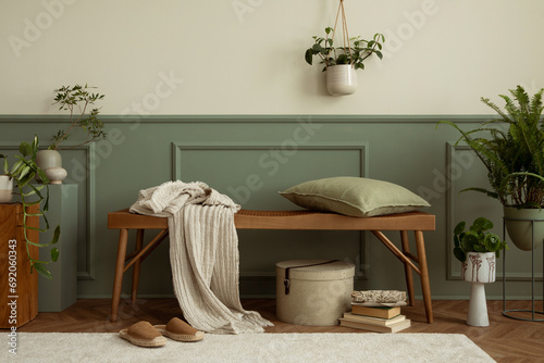 Minimalist composition of cozy living room interior with wooden bench, plants in flowerpots, wall with stucco, books, brown slippers, round box and personal accessories. Home decor Template. photo