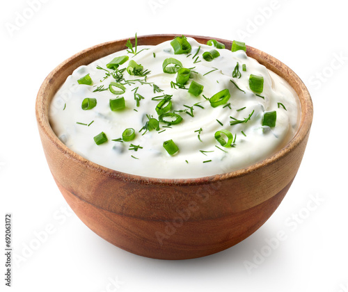 Wooden bowl of fresh sour cream dip sauce with herbs and green onions