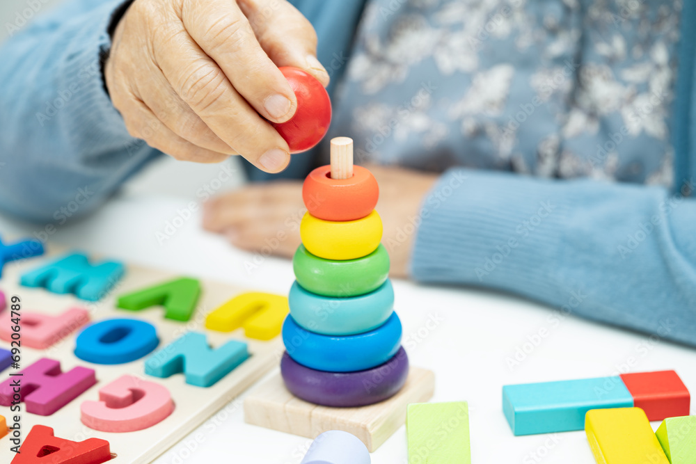 Alzheimer disease AD, Asian elderly woman patient suffering from dementia learn practical motor skills rehabilitation. Alzheimer disease AD, Asian elderly woman patient suffering from dementia learn practical motor skills rehabilitation.