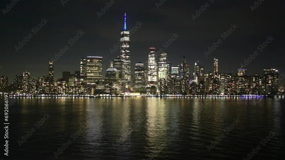 view of downtown new york city skyline (lower manhattan, financial district) water flowing footage (sunset, night time, dusk, blue hour, golden hour) tall buildings skyscrapers, boat, barge, ferry view of downtown new york city skyline (lower manhattan, financial district) water flowing footage (sunset, night time, dusk, blue hour, golden hour) tall buildings skyscrapers, boat, barge, ferry