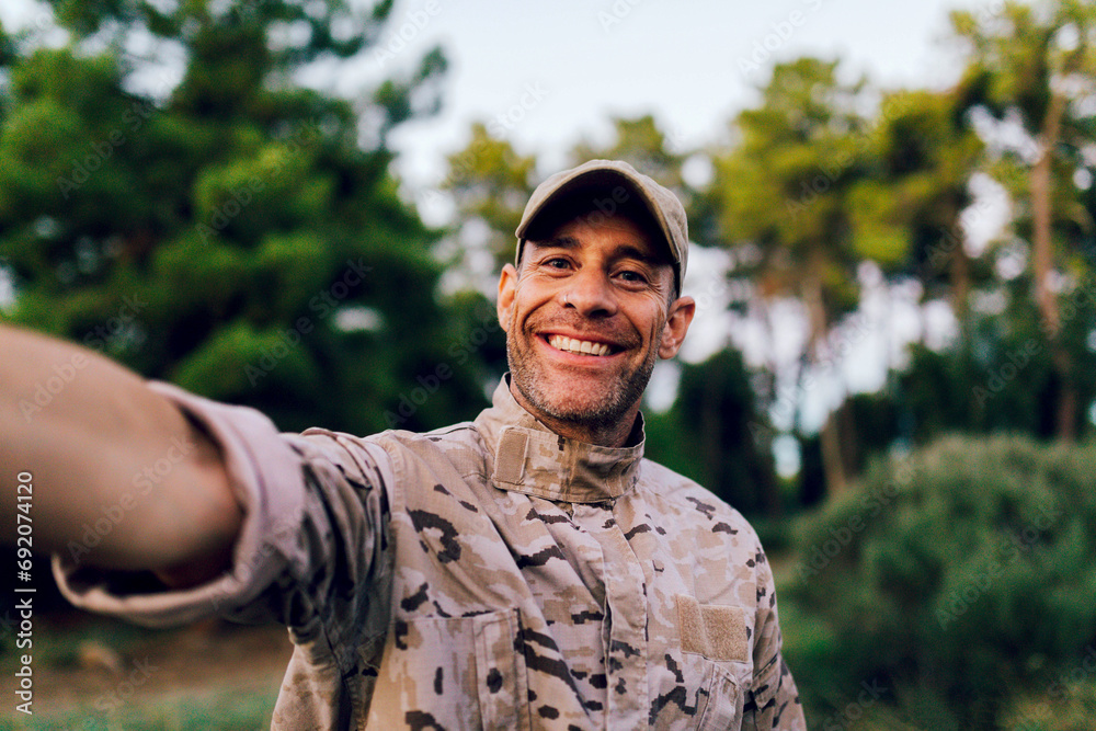 Happy middle aged ranger in uniform looking at camera while taking selfie Happy middle aged ranger in uniform looking at camera while taking selfie
