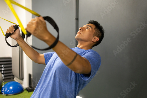 Man engaging in suspension training at gym photo