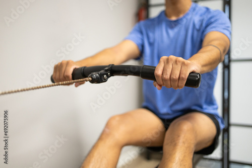 Man exercising with a rowing machine at the gym photo