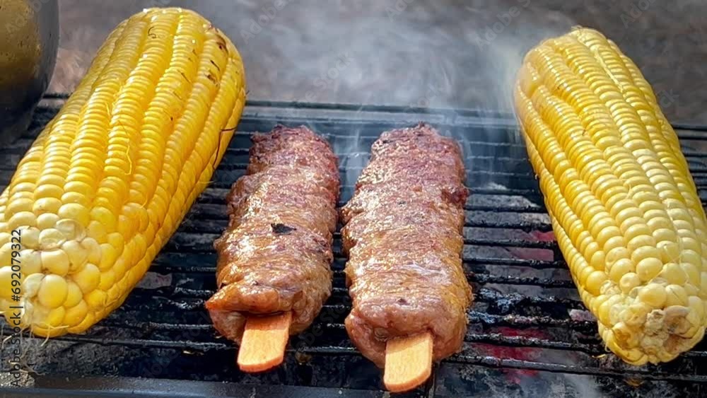 Grilled corns with skewered minced meat kebab fried on wooden sticks. Lula kebab, a specialty of Turkish Azerbaijani and Armenian cuisines. Lüle, Lyulya, Adana or Urfa kebap. BBQ Close Up
Grilled corns with skewered minced meat kebab fried on wooden sticks. Lula kebab, a specialty of Turkish Azerbaijani and Armenian cuisines. Lüle, Lyulya, Adana or Urfa kebap. BBQ Close Up