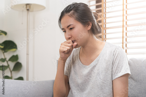 Free Download Sick, hurt or pain asian young woman, girl sore throat, cough have a fever, flu and sneezing nose, runny sitting on sofa, couch at home. Health care person on virus seasonal. - GFXLoad