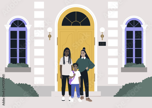 A full length multiracial family portrait, a lesbian couple and their son at the entrance door on a first day of school