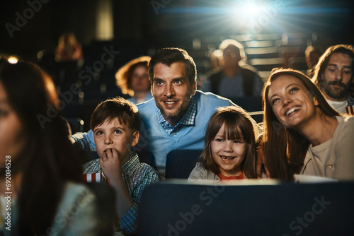 Happy young family in the cinema watching movie photo