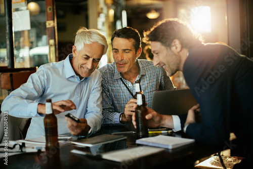 Businessmen having beer after work in bar or cafe photo