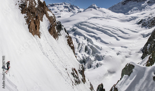 From above of unrecognizable Skier Descending a Steep Glacier Ridge in Zermatt photo