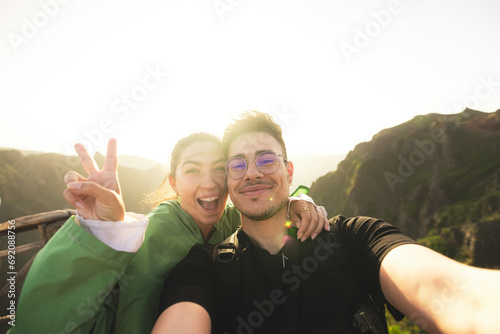 Happy friends at mountain peak during sunrise